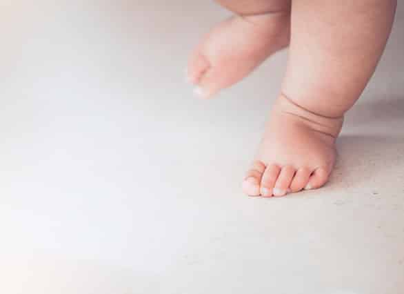 Small-baby-feet-doing-the-first-step-on-the-floor