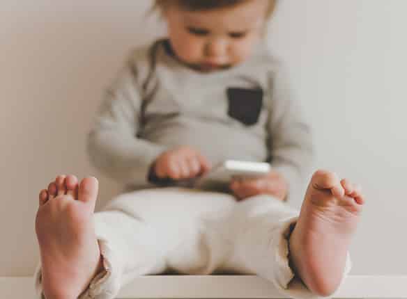 Toddler-with-a-smartphone-in-light-interior