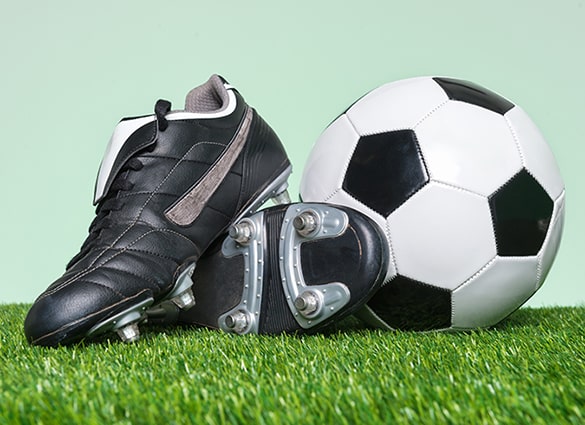 football-or-soccer-boots-and-ball-on-grass