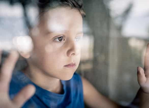 one-sad-little-boy-standing-near-the-window