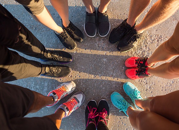 runners-standing-in-a-huddle-with-their-feet