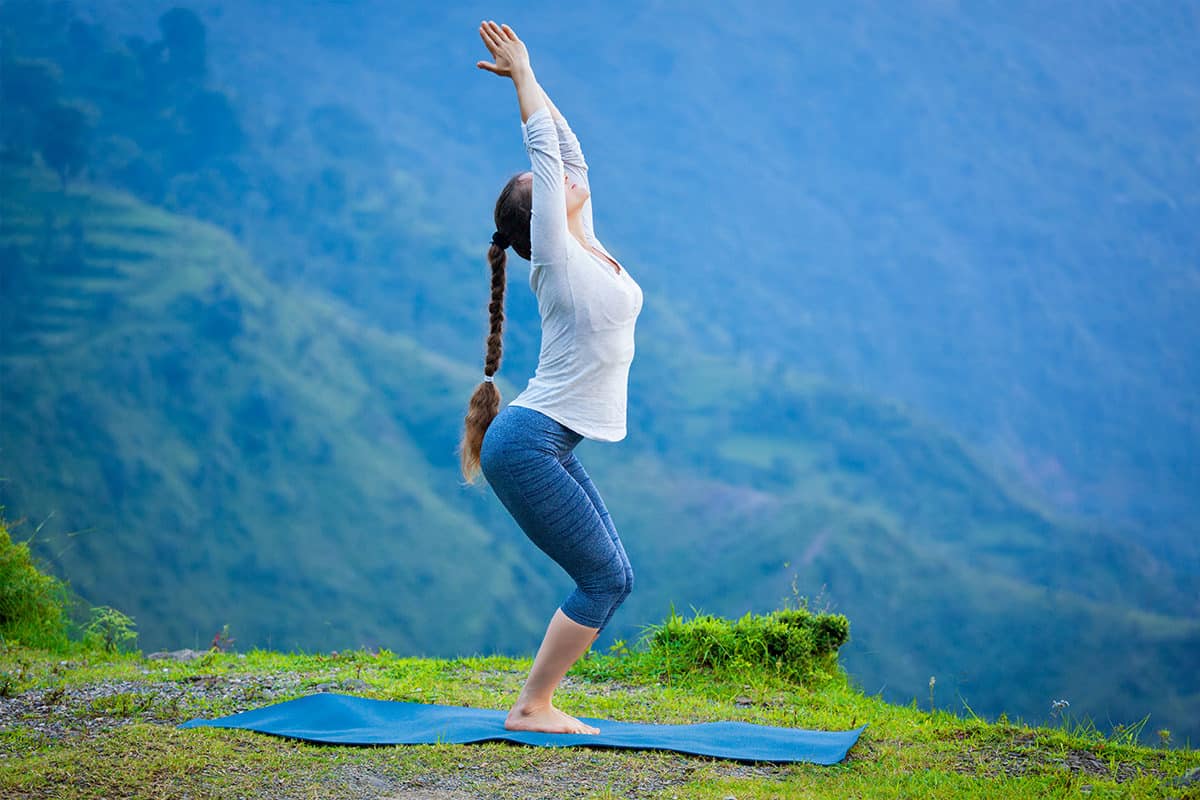 woman-doing-yoga-asana-utkatasana-outdoors